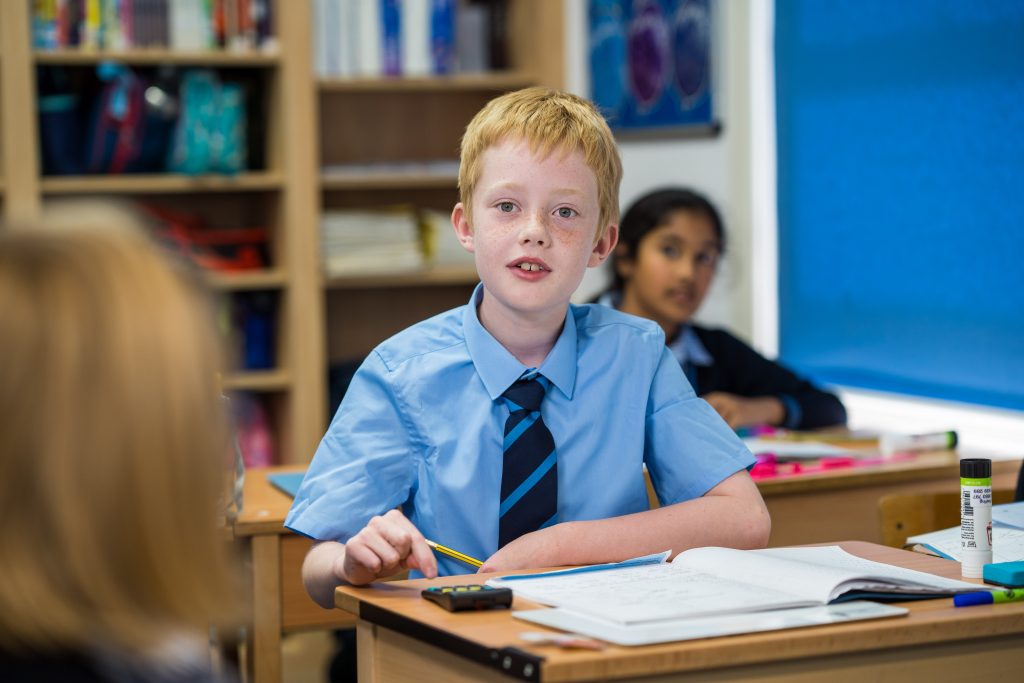 girl and boy sitting at desks