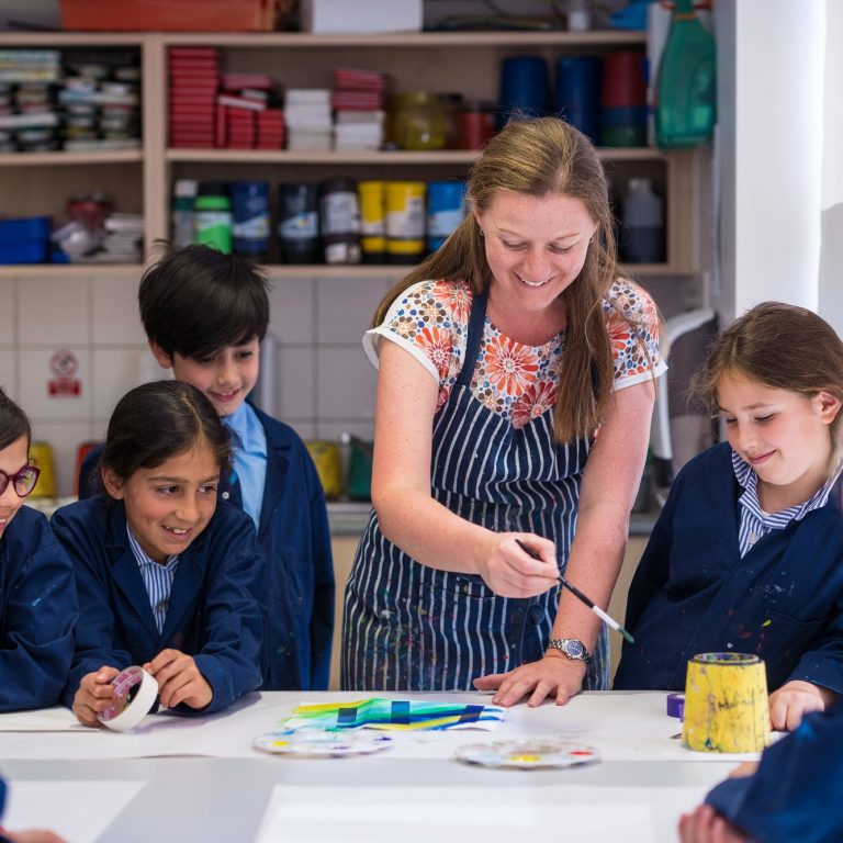 A teacher demonstrating what to do with the paintbrush in the next art project