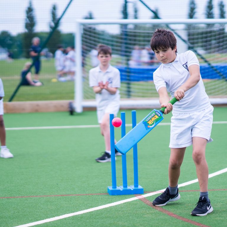 Student hitting a ball with the cricket bat