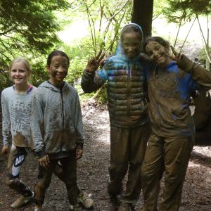 Very muddy students still smiling after walking through the woods
