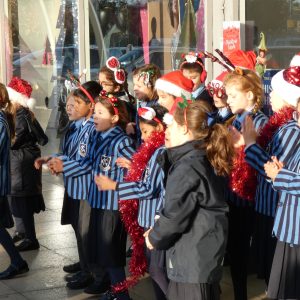 children carolling outside of school