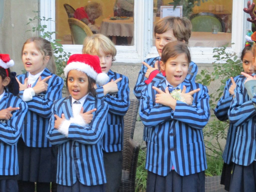 children stood outside in Christmas hats