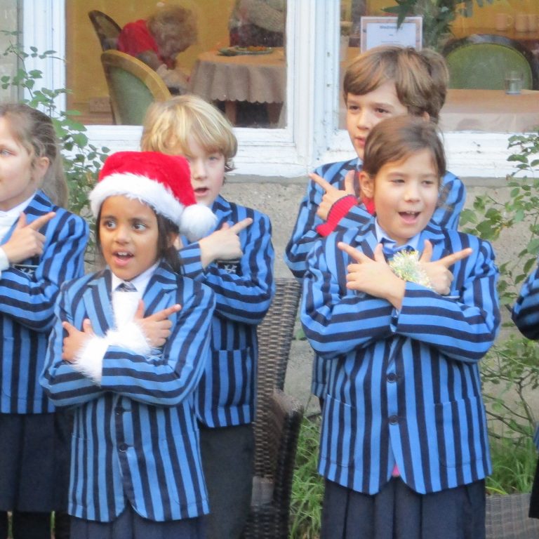 children stood outside in Christmas hats