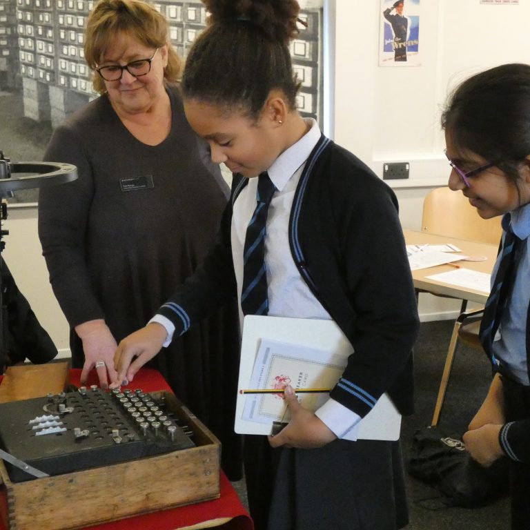 student touching an old typewriter