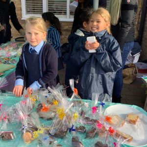 students selling cakes for charity
