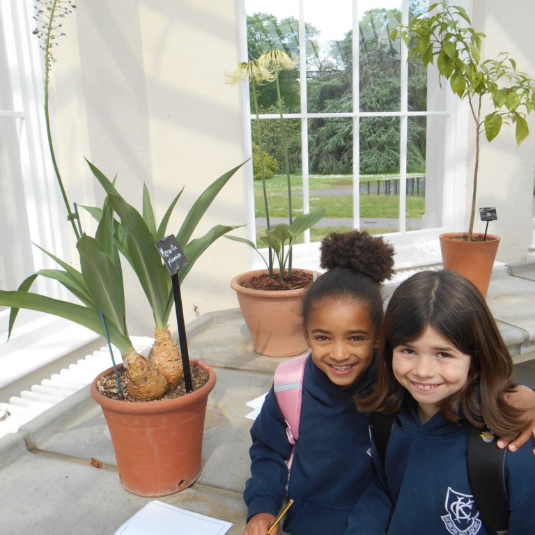 girls stood by a plant