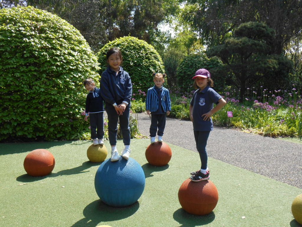 students stood on colourful balls