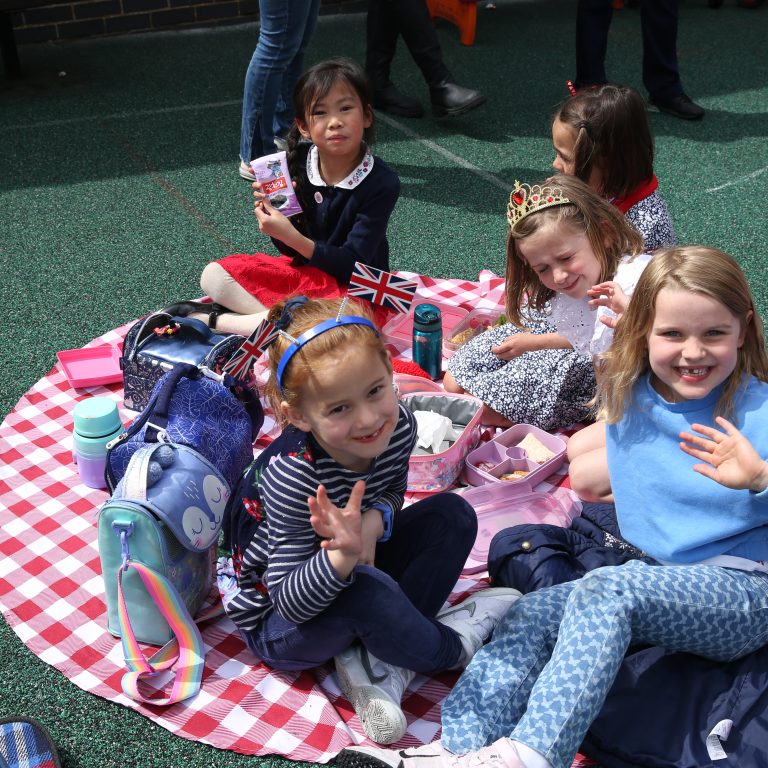 girls waving to the camera as they eat