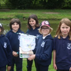 children holding a paper boat